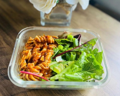 Affordable and diverse meal idea: container with pasta and salad.