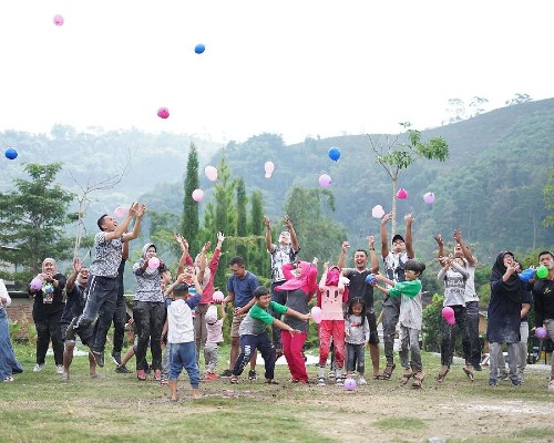 A diverse group engages in playful activity by tossing balloons into the air, capturing different perspectives on fun and entertainment